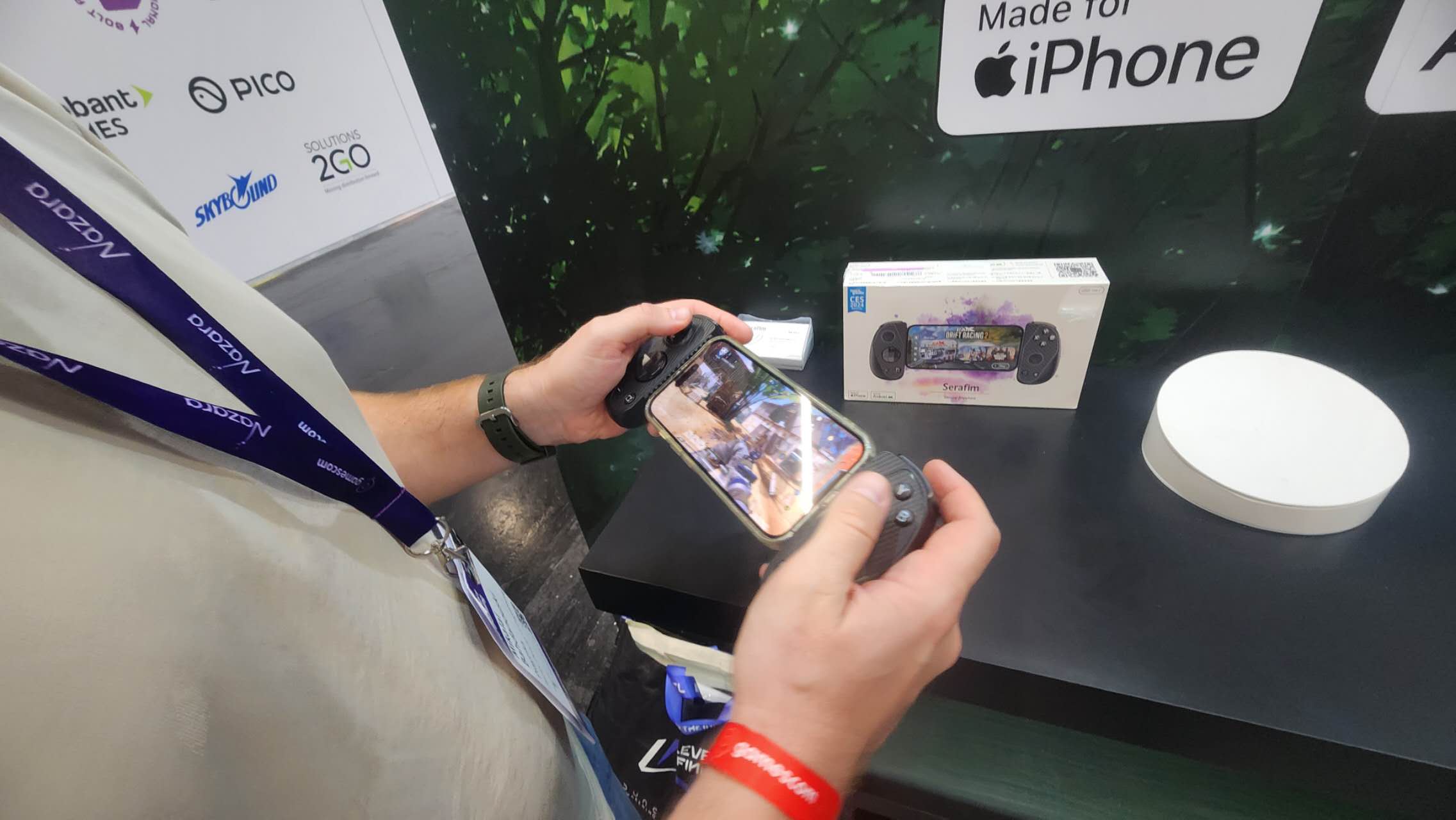 Close-up of an attendee playing a mobile game with the Serafim S3 controller during a hands-on demo at Gamescom 2026.